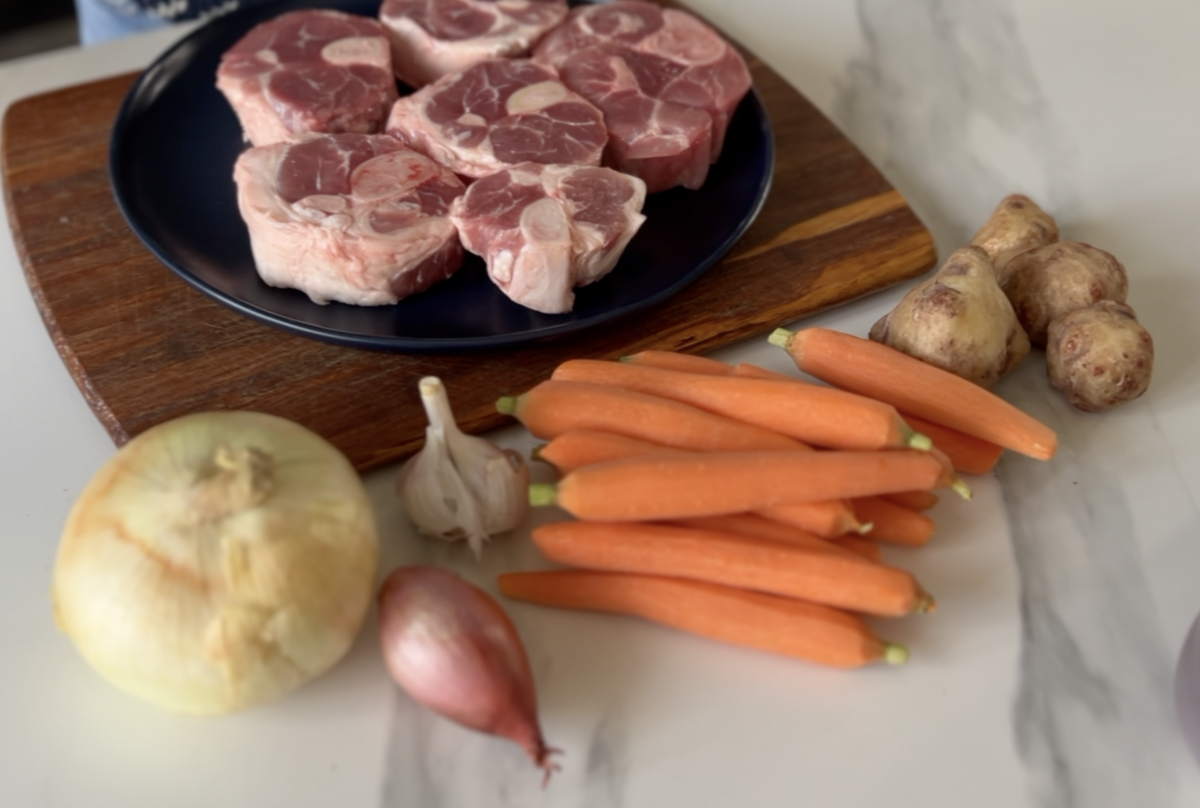 osso bucco de porc, oignon, échalote, carottes, topinambours sur une planche sur le comptoir
